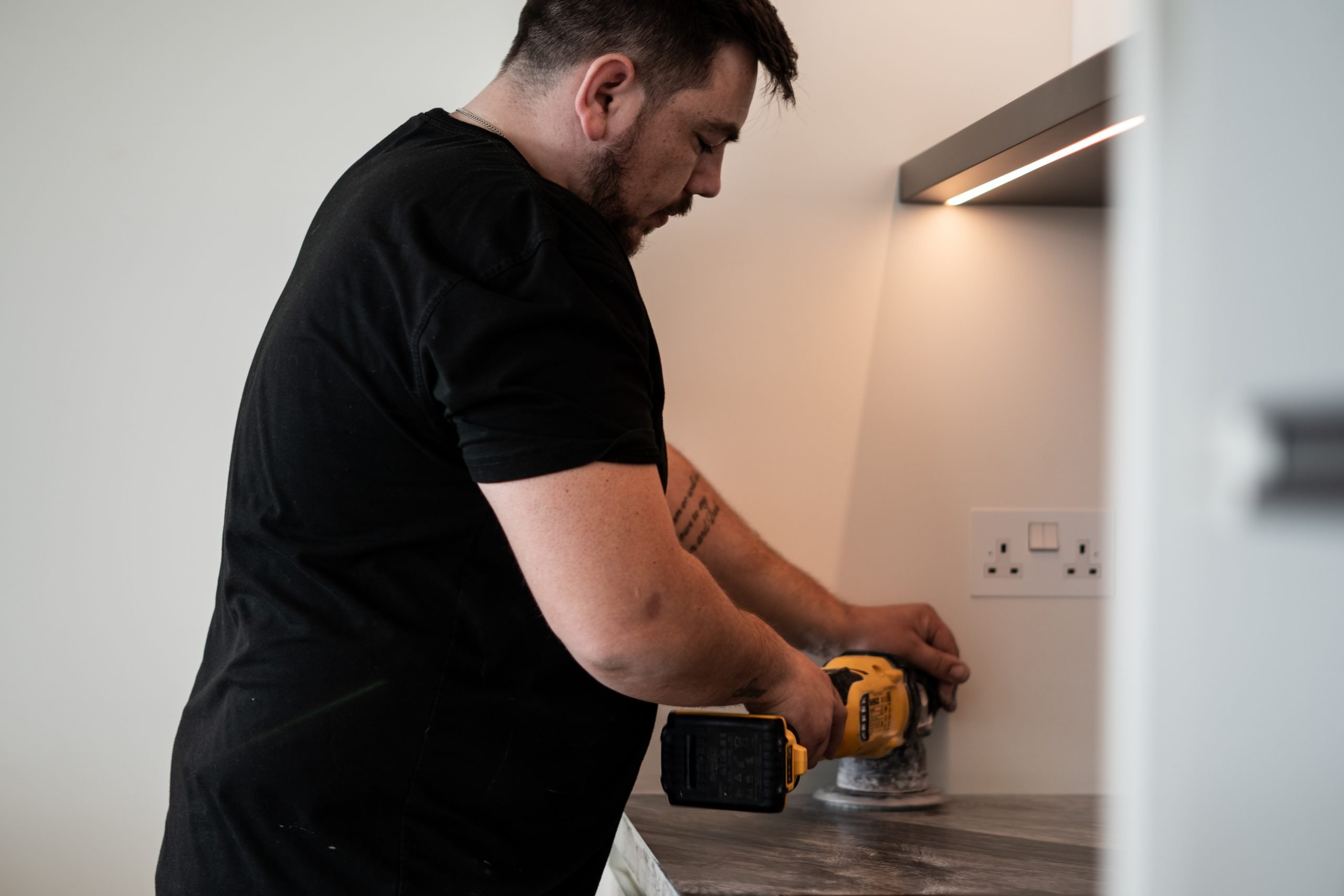 A MasterTeck Repair technician restoring a stone kitchen worktop on site
